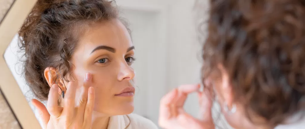 woman-looking-mirror-doing-beauty-face-routine.png woman-looking-mirror-doing-beauty-face-routine.png style=