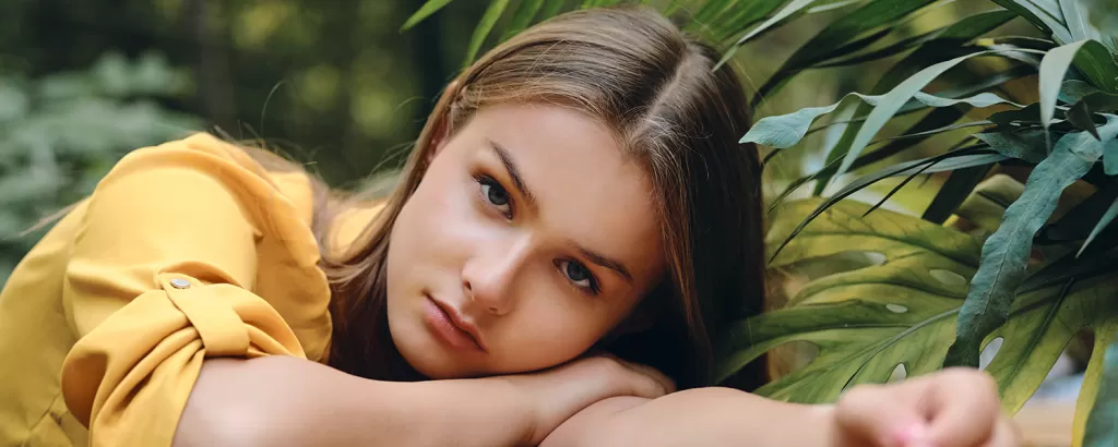 young-serious-brown-haired-woman-yellow-shirt-lying-hand-while-thoughtfully-looking-camera-around-green-leaves-park.jpg.png style= young-serious-brown-haired-woman-yellow-shirt-lying-hand-while-thoughtfully-looking-camera-around-green-leaves-park.jpg.png